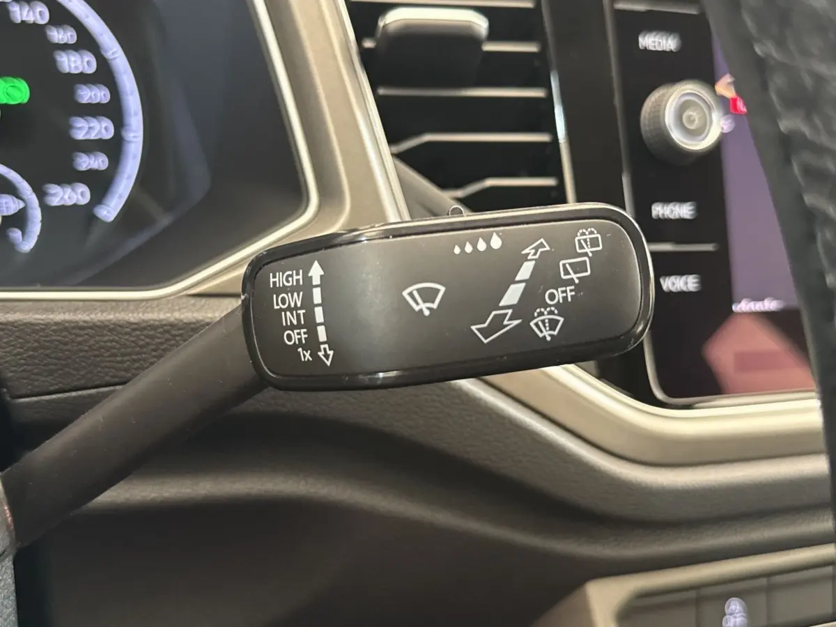 Gros plan sur la manette d’essuie-glace côté droit du tableau de bord du Volkswagen T-Roc bleu 2020.