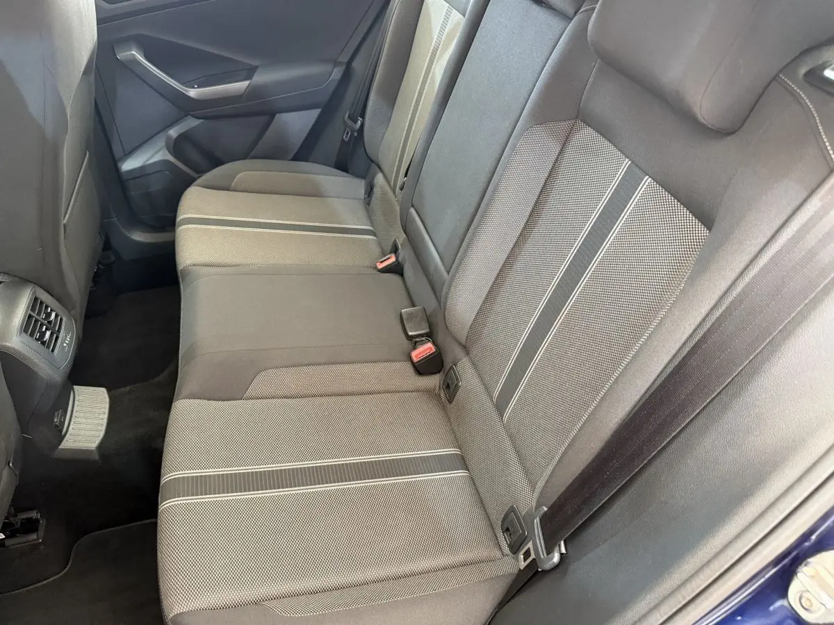 Vue côté droit de la banquette arrière grise à motifs du Volkswagen T-Roc bleu, avec ceinture et porte arrière visible.