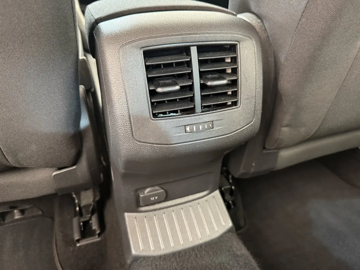 Vue rapprochée des aérateurs arrière et prise 12V entre les sièges noirs du Volkswagen T-Roc 2020.