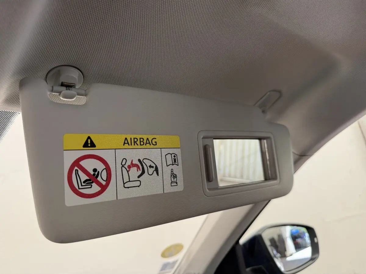Détail du pare-soleil côté conducteur avec miroir et avertissement airbag dans un Volkswagen T-Roc bleu 2020.