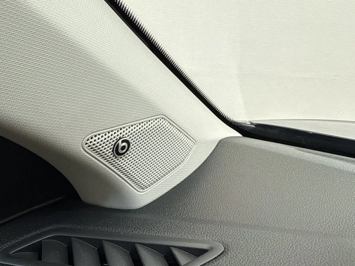 Gros plan sur l'enceinte Beats intégrée côté gauche du tableau de bord du Volkswagen T-Roc bleu 2020.