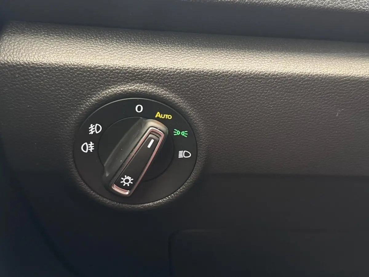 Gros plan sur la molette de commande des phares du Volkswagen T-Roc 2.0 TDI bleu, affichage des options d’éclairage.