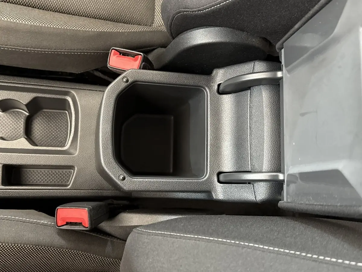 Vue plongeante sur le rangement central noir entre les sièges avant du Volkswagen T-Roc 2.0 TDI 150 bleu de 2020.