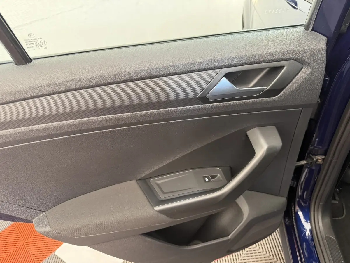 Vue rapprochée de la porte avant droite bleu foncé du Volkswagen T-Roc 2020 avec poignée et bouton de verrouillage.