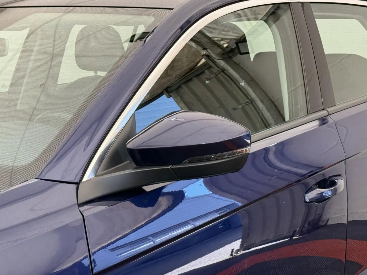 Gros plan sur le rétroviseur et la porte côté conducteur d’un Volkswagen T-Roc bleu métallisé 2020.