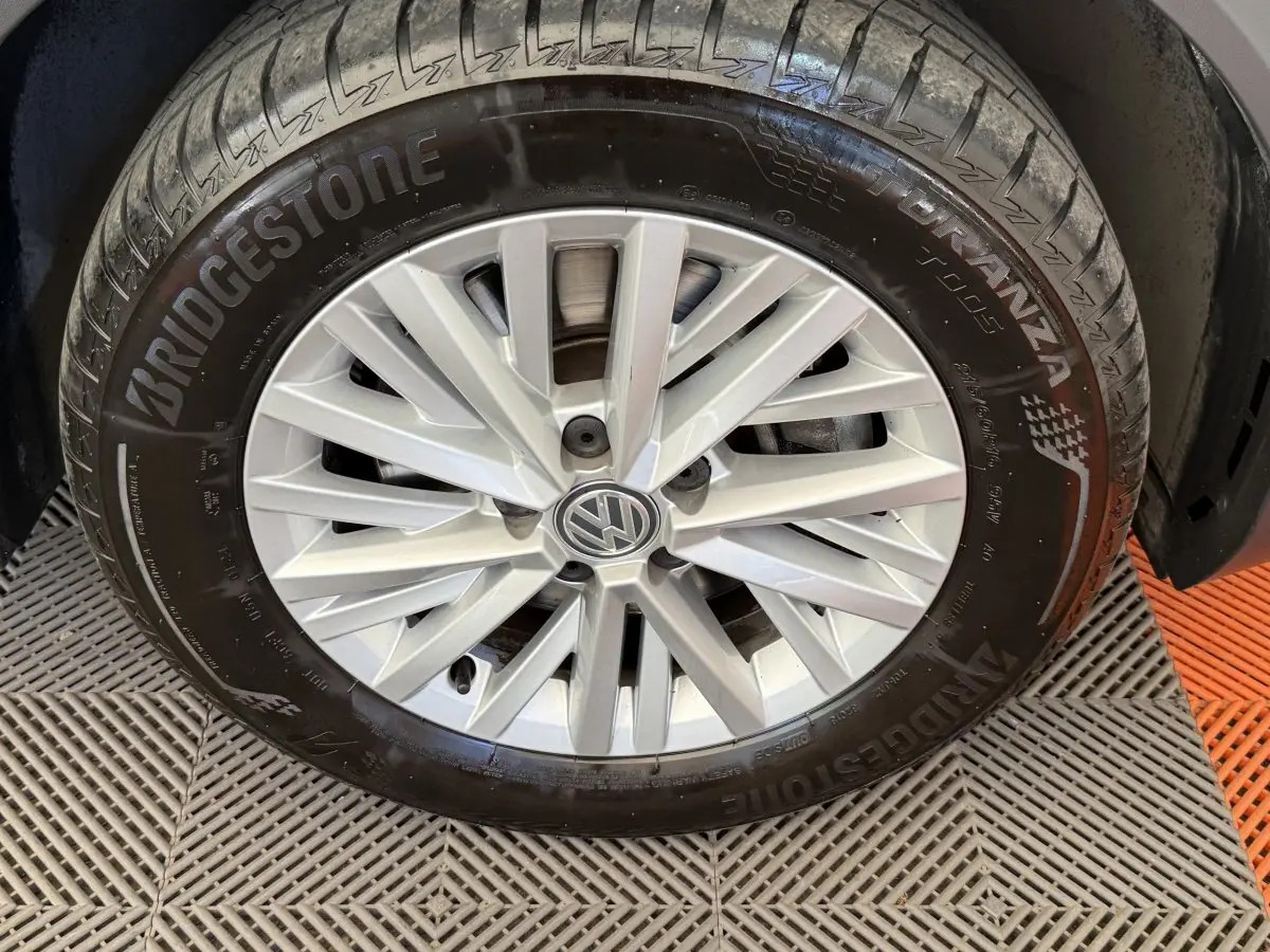 Gros plan sur la jante argentée de Volkswagen T-Roc 2.0 TDI 150 IQ.DRIVE avec pneu Bridgestone noir.