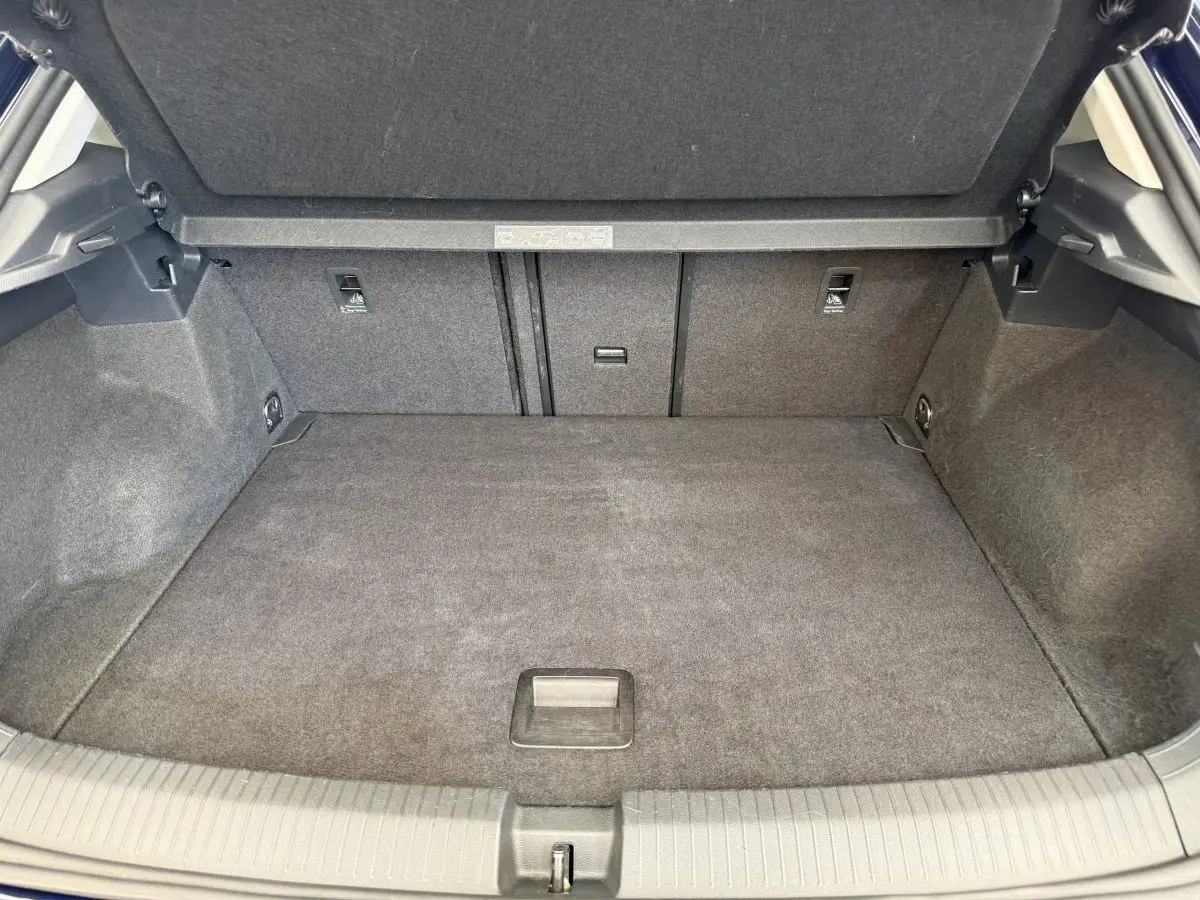 Coffre spacieux et propre du Volkswagen T-Roc bleu, vue intérieure arrière avec banquette rabattue et plancher plat.