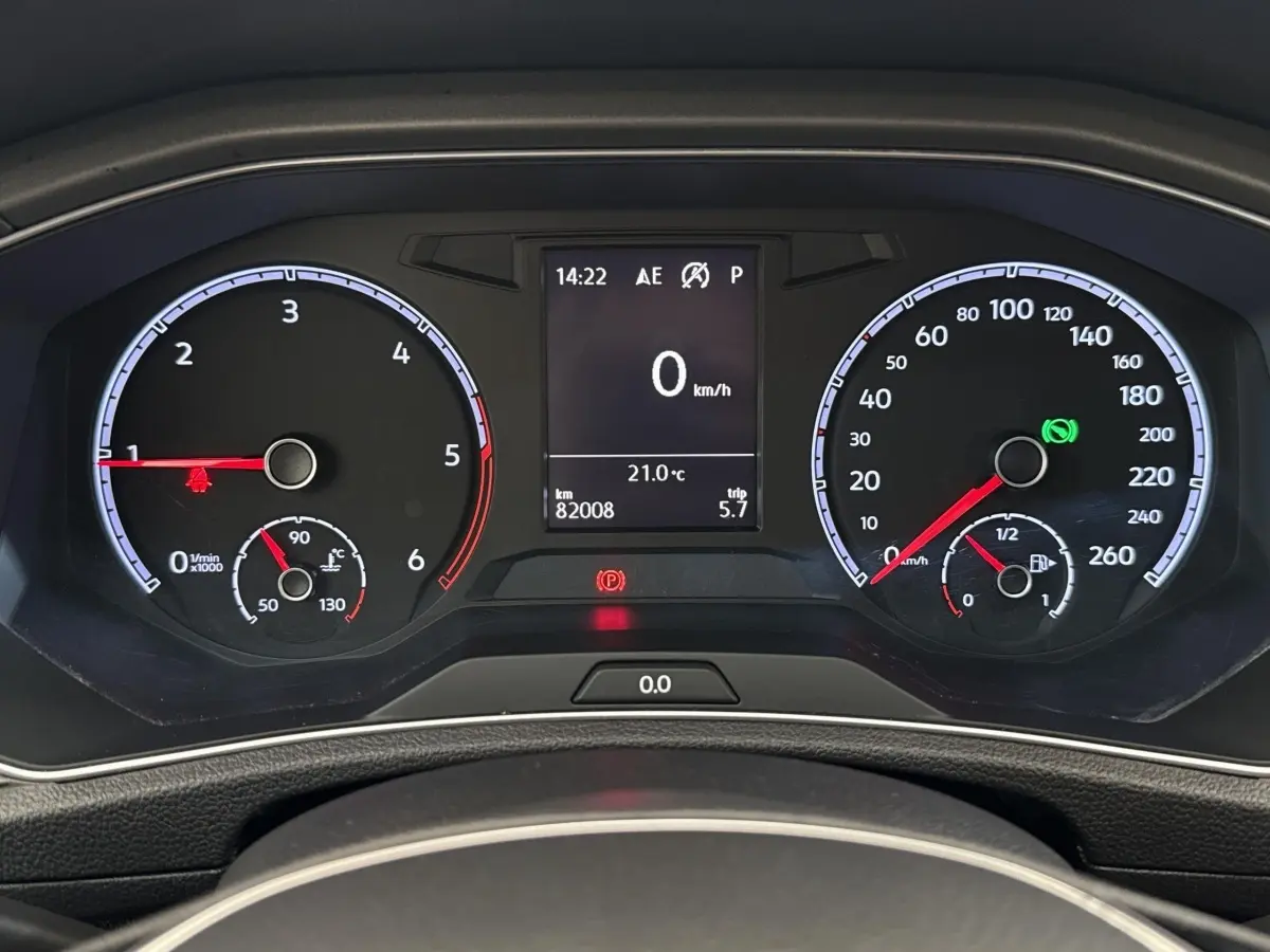 Vue rapprochée du tableau de bord numérique du Volkswagen T-Roc 2.0 TDI, affichant la vitesse à 0 km/h et la température à 21°C.