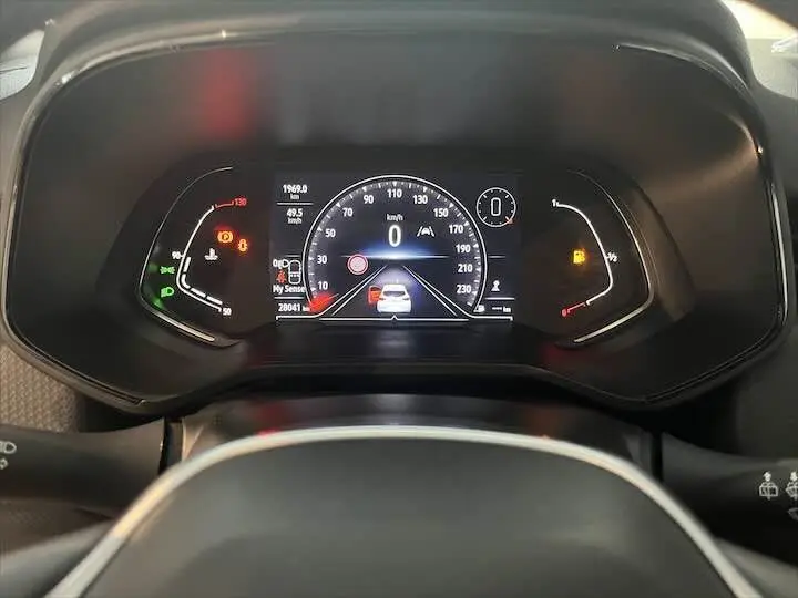 Vue rapprochée du tableau de bord numérique de la Renault Clio V, affichant la vitesse et alertes au centre.