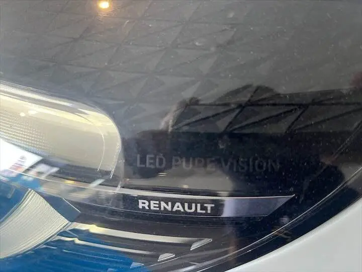 Gros plan sur le phare avant gauche blanc nacré d'une Renault Clio V avec inscription LED Pure Vision visible.