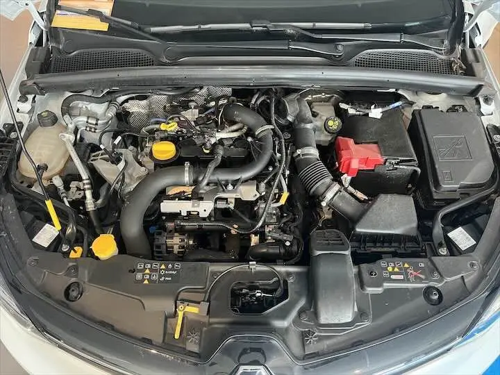 Moteur essence de Renault Clio V blanc nacré vu de dessus avec capot ouvert montrant les composants du bloc moteur.