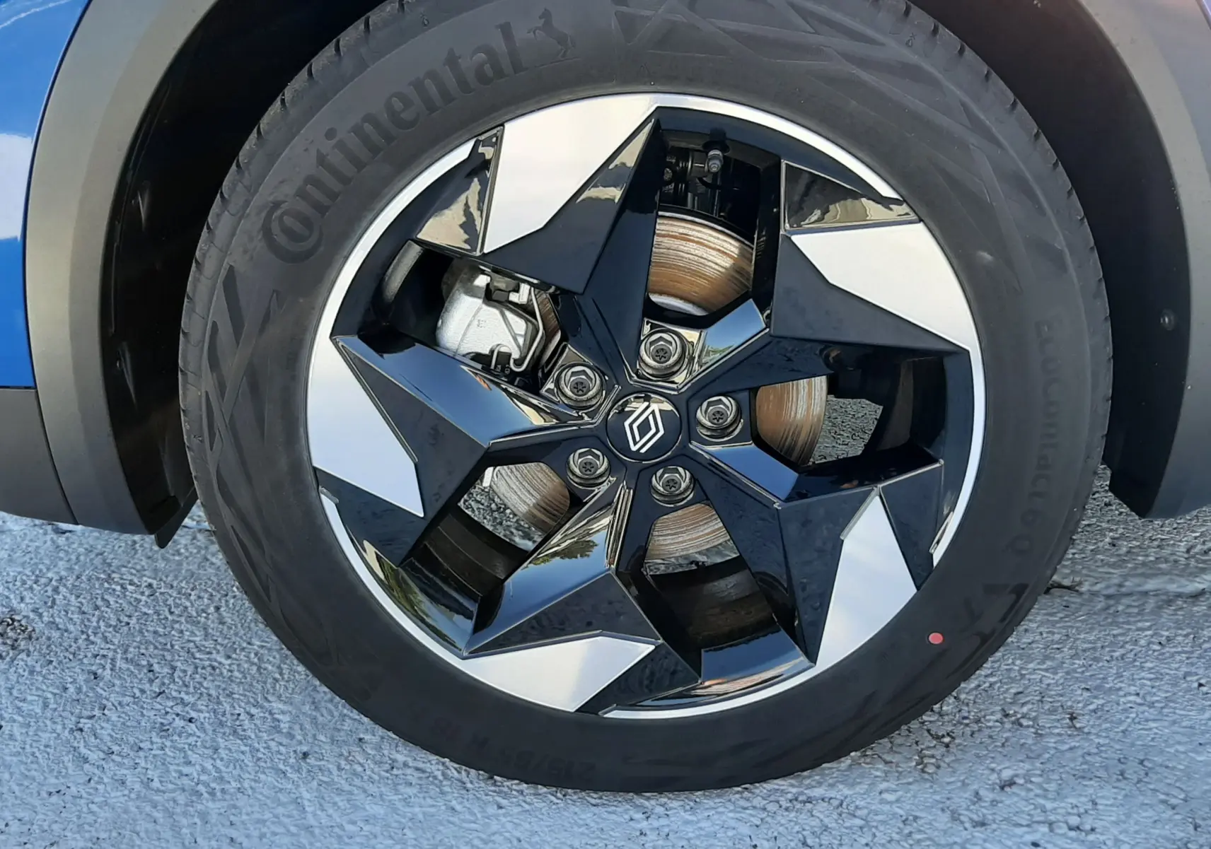 Gros plan sur la jante noire et argentée du côté avant gauche d'un Renault Captur bleu iron au toit noir.