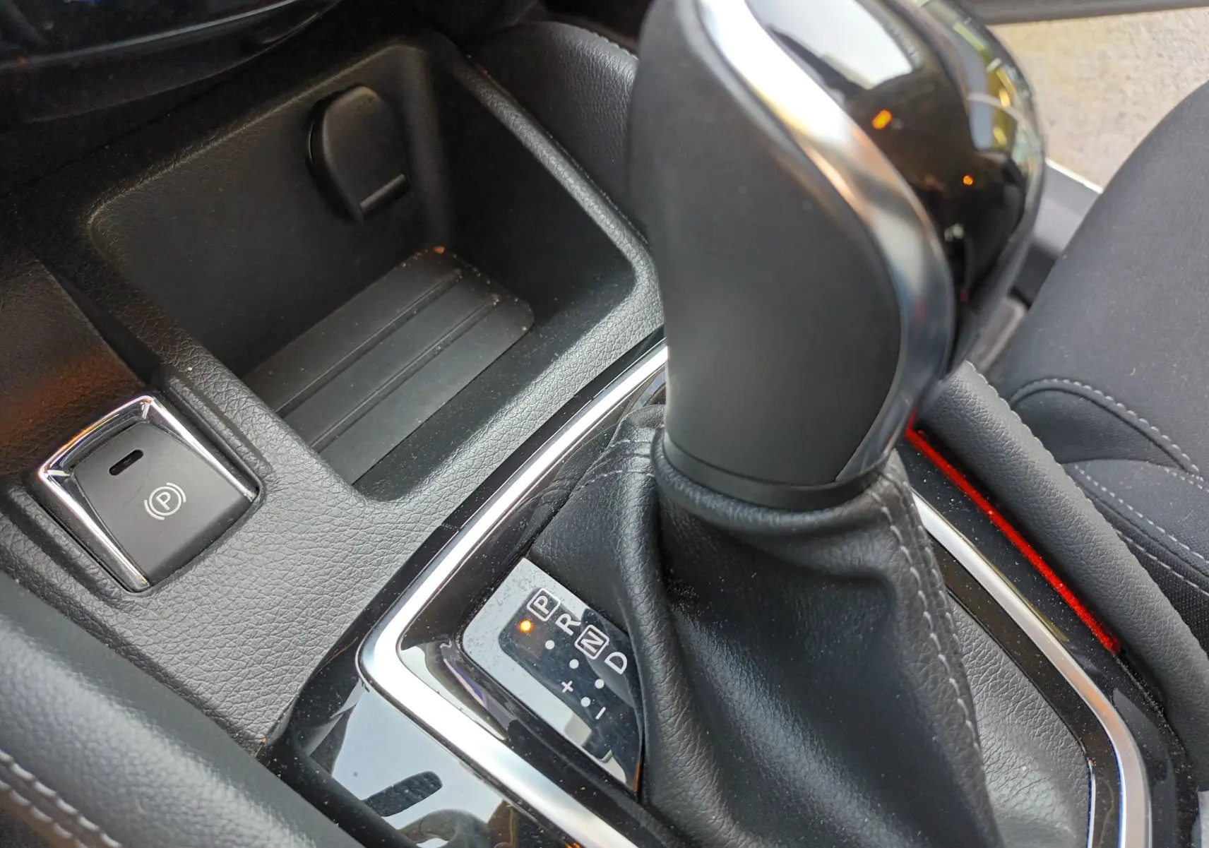 Gros plan sur le levier de vitesse automatique et le frein à main électrique du Nissan Qashqai blanc nacré 2019.