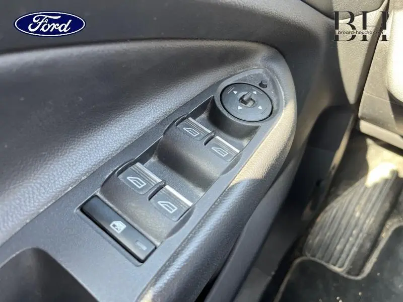 Gros plan sur les commandes électriques des vitres côté gauche d'un Ford Kuga blanc Glacier 2017 avec réglage des rétroviseurs.