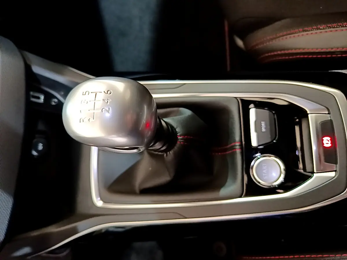 Gros plan sur levier de vitesses manuel gris argenté et console centrale noire avec surpiqûres rouges dans Peugeot 308 GT Line 2016.