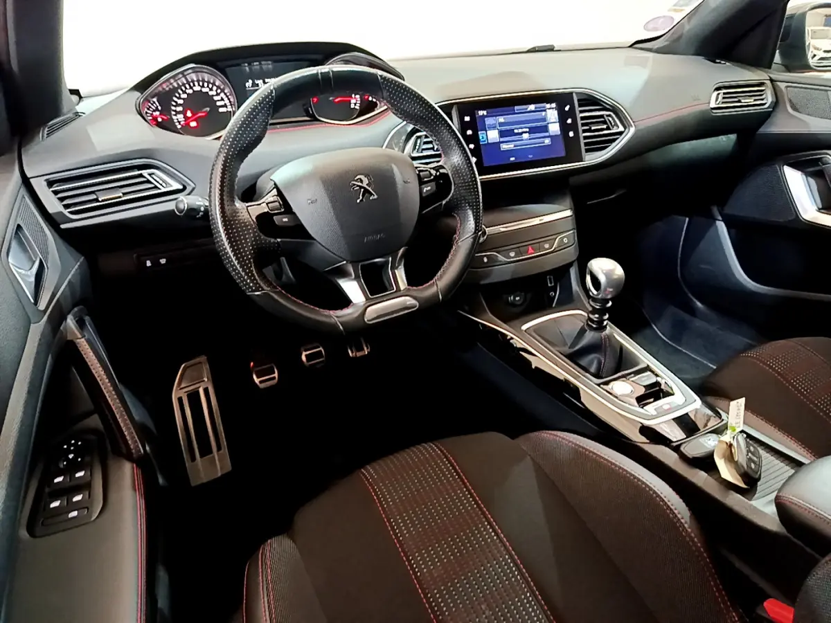 Intérieur de la Peugeot 308 GT Line 2016, vue du poste de conduite avec volant cuir et écran tactile central.