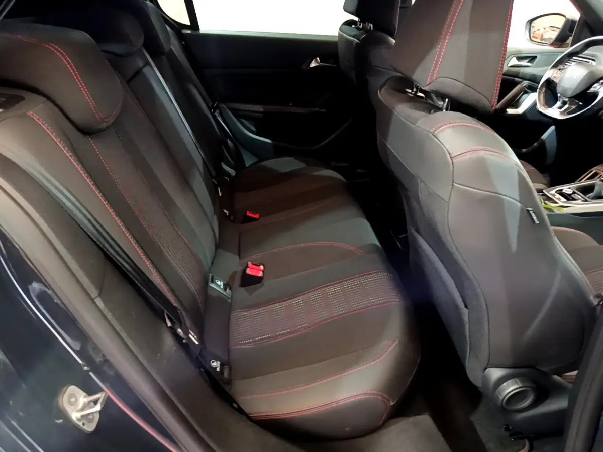 Vue intérieure côté gauche sur la banquette arrière noire avec surpiqûres rouges du Peugeot 308 gris foncé 2016.