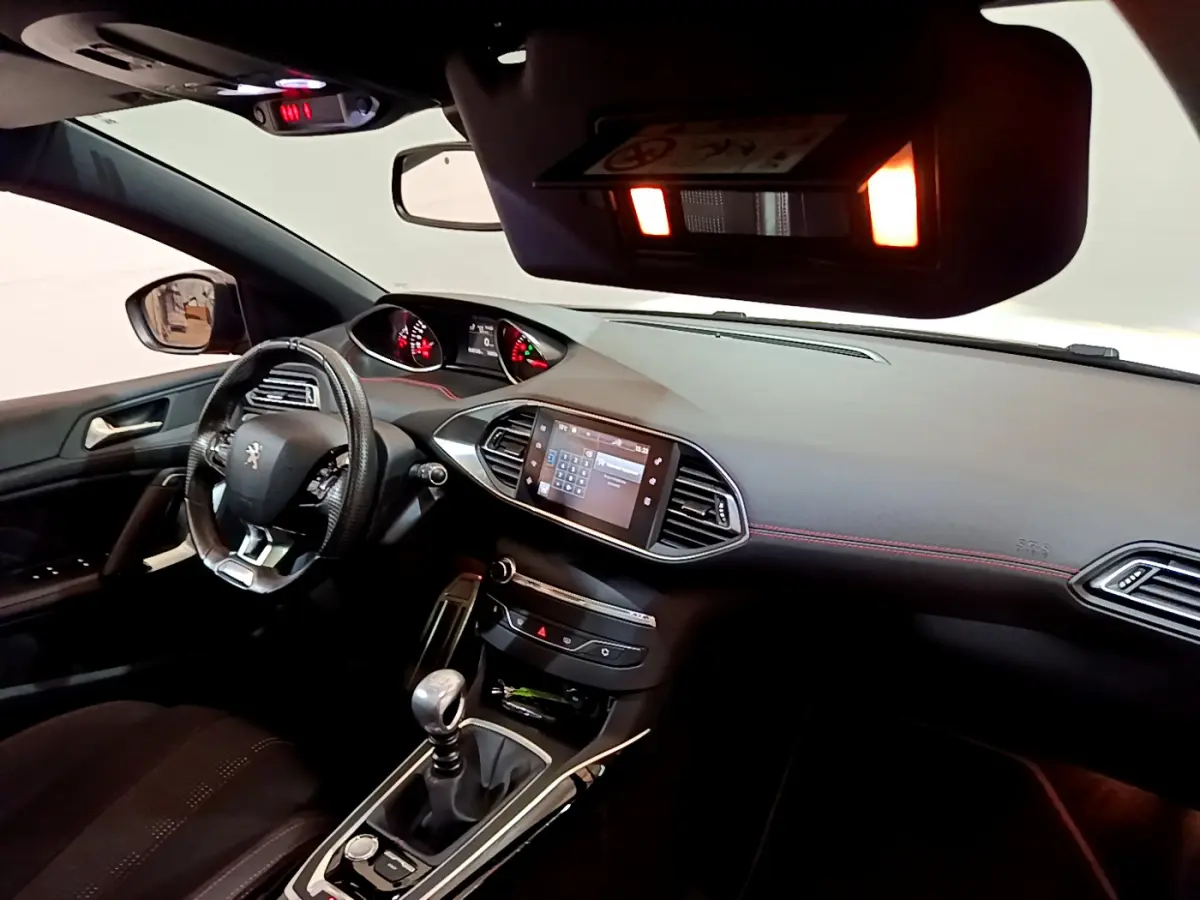 Intérieur Peugeot 308 GT Line 2016 vu côté conducteur, tableau de bord noir avec écran tactile 9,7 pouces et volant cuir.