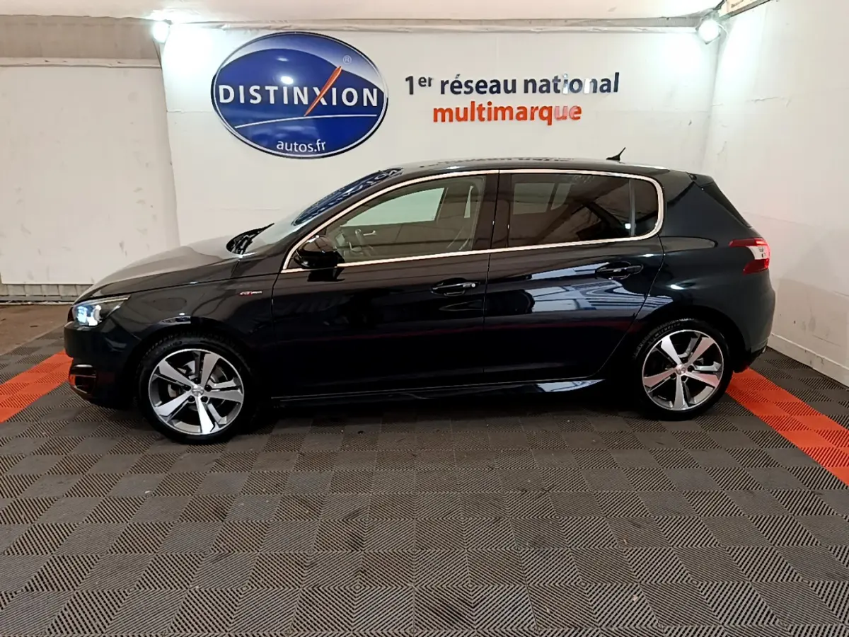 Profil côté gauche d'une Peugeot 308 gris foncé 2016 GT Line avec jantes alliage et feux LED allumés.