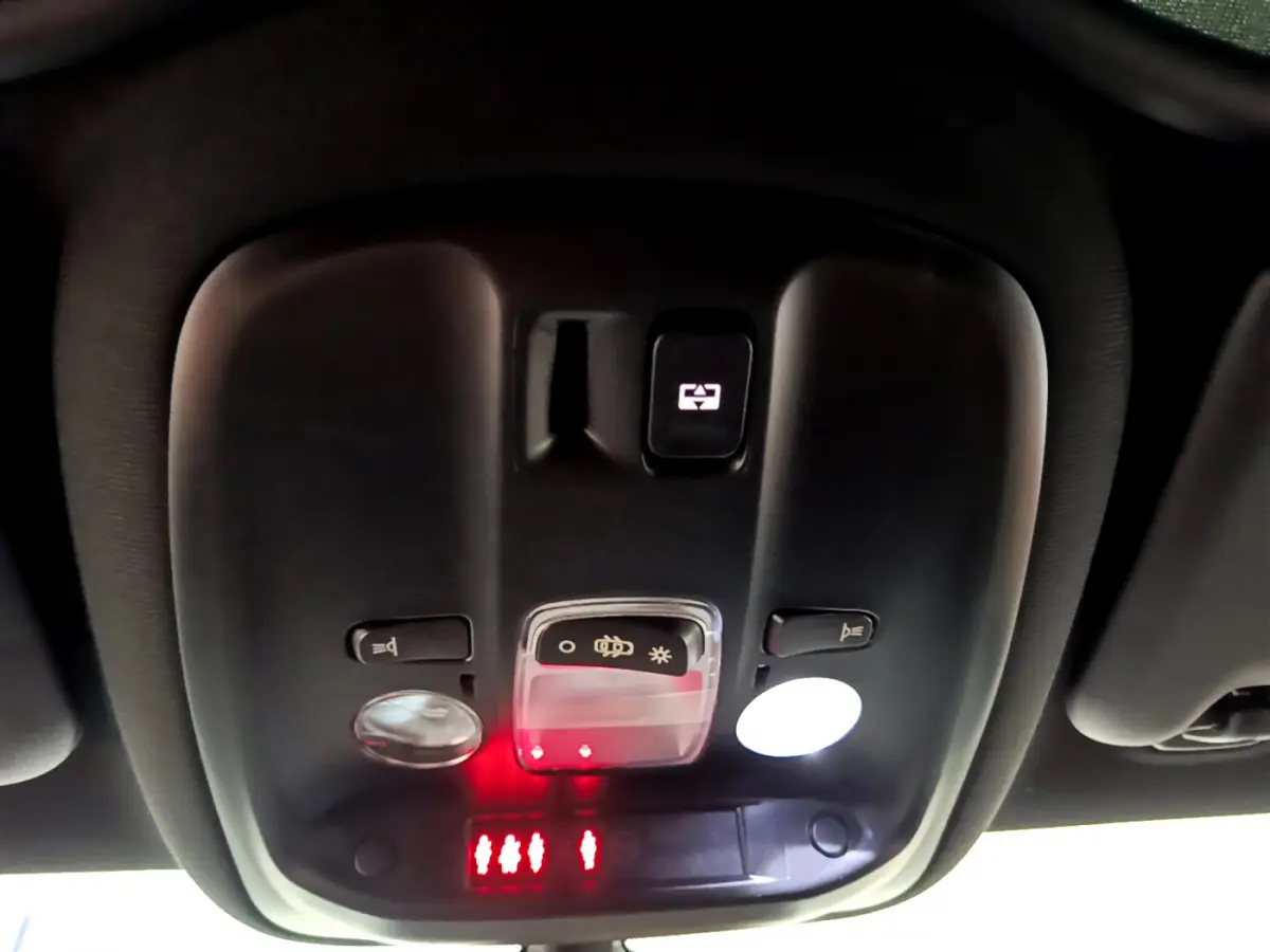 Vue en gros plan du plafonnier noir de la Peugeot 308 GT Line 2016 avec commandes d'éclairage et indicateurs rouges allumés.