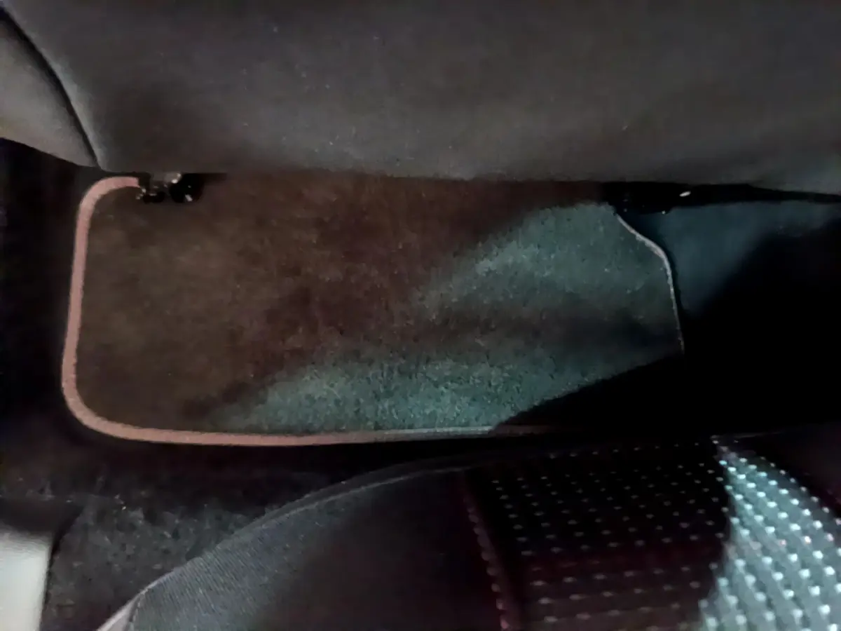 Tapis de sol noir avec surpiqûres rouges côté passager arrière d'une Peugeot 308 gris foncé 2016.