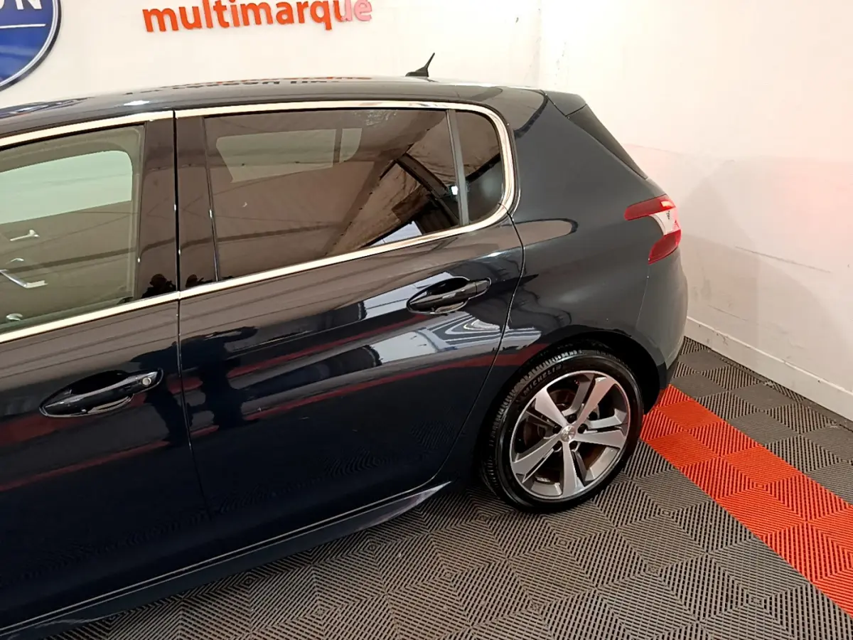 Vue latérale arrière droite d'une Peugeot 308 gris foncé avec jantes alliage et vitres teintées.