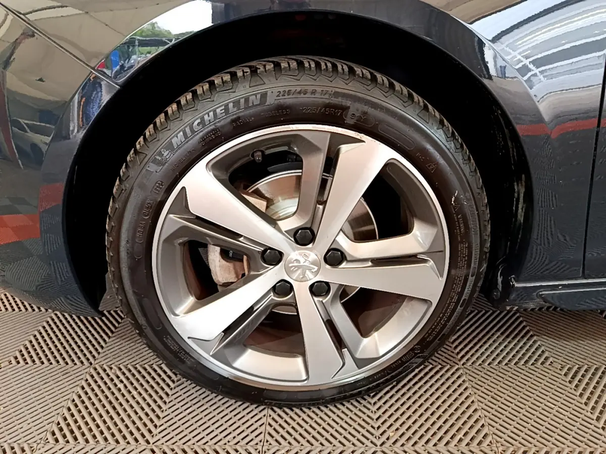 Gros plan sur la roue avant gauche gris foncé de la Peugeot 308 1.2 PureTech avec jante alliage cinq branches.