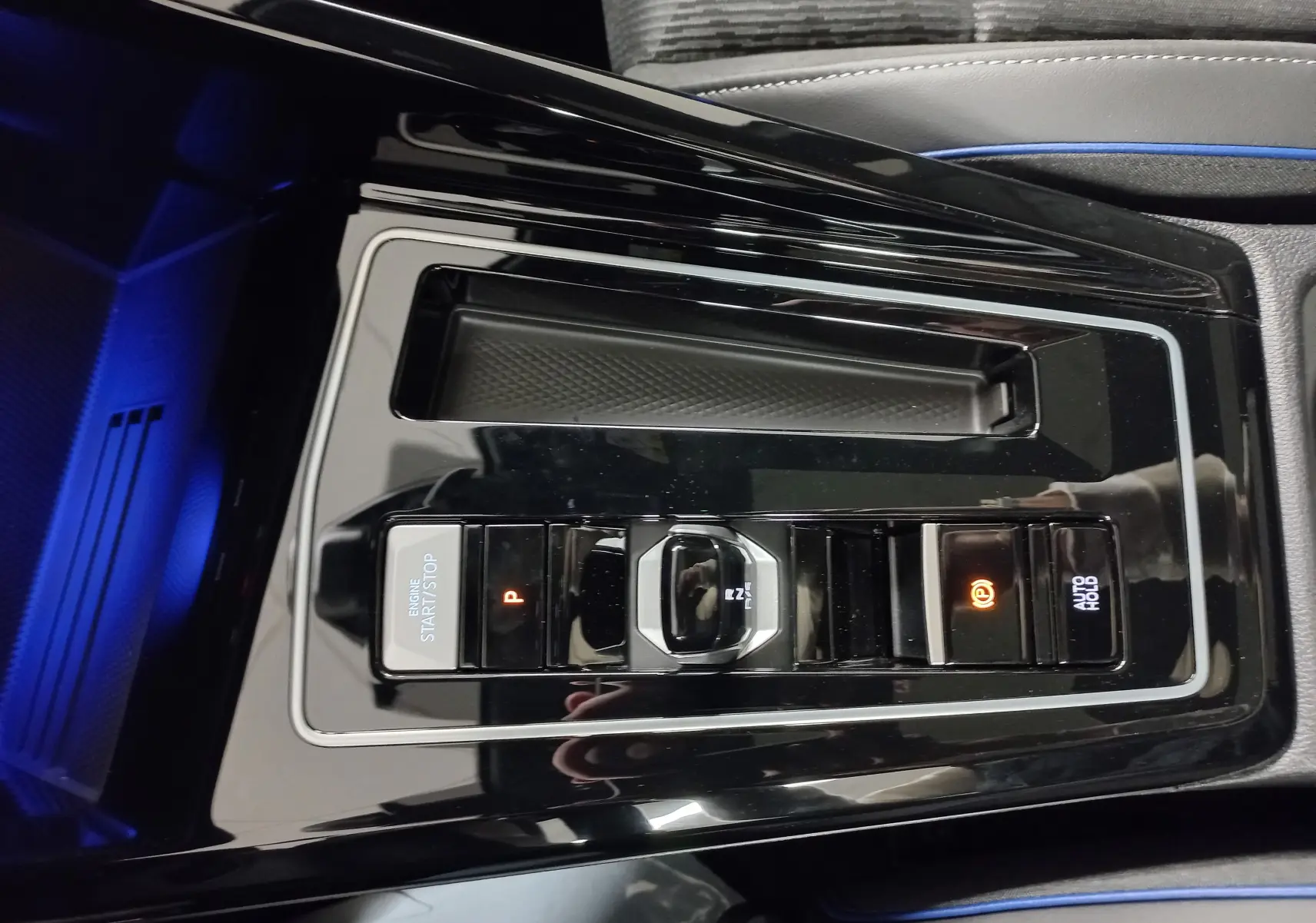 Vue rapprochée de la console centrale noire brillante de la Volkswagen Golf 2.0 TDI R-Line avec commandes de boîte auto et frein électronique.