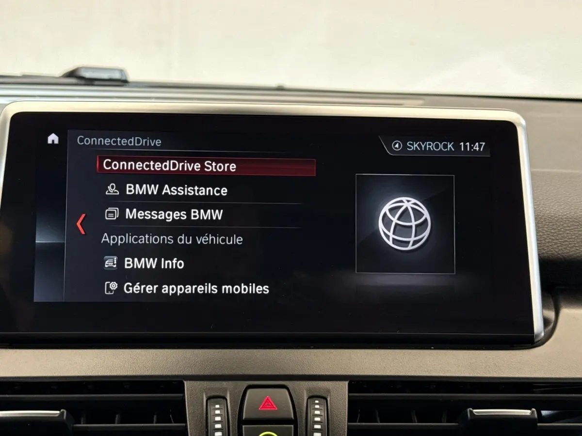 Écran tactile central du tableau de bord de la BMW Série 2 Active Tourer 225xe gris foncé, affichant le menu ConnectedDrive.