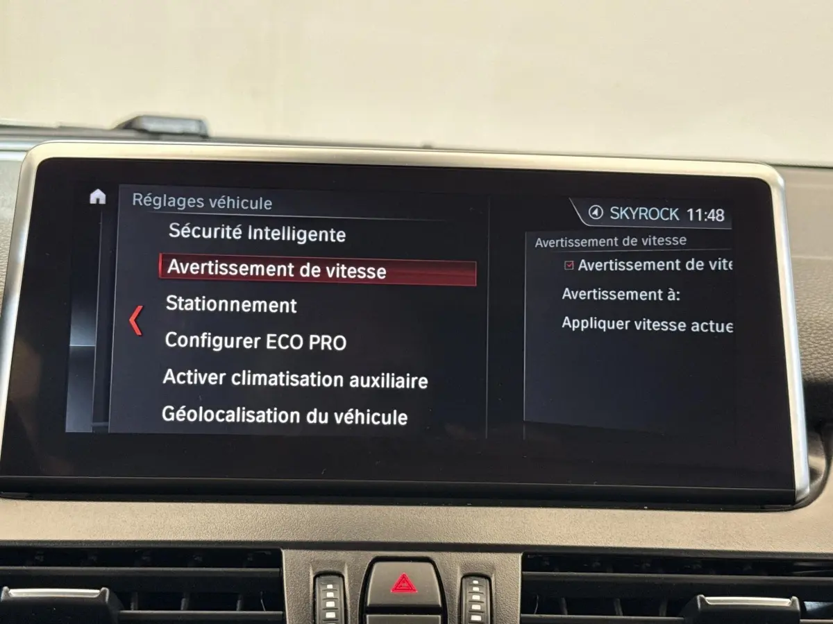 Écran tactile intérieur de BMW Série 2 Active Tourer 225xe gris foncé affichant les réglages de sécurité et vitesse.