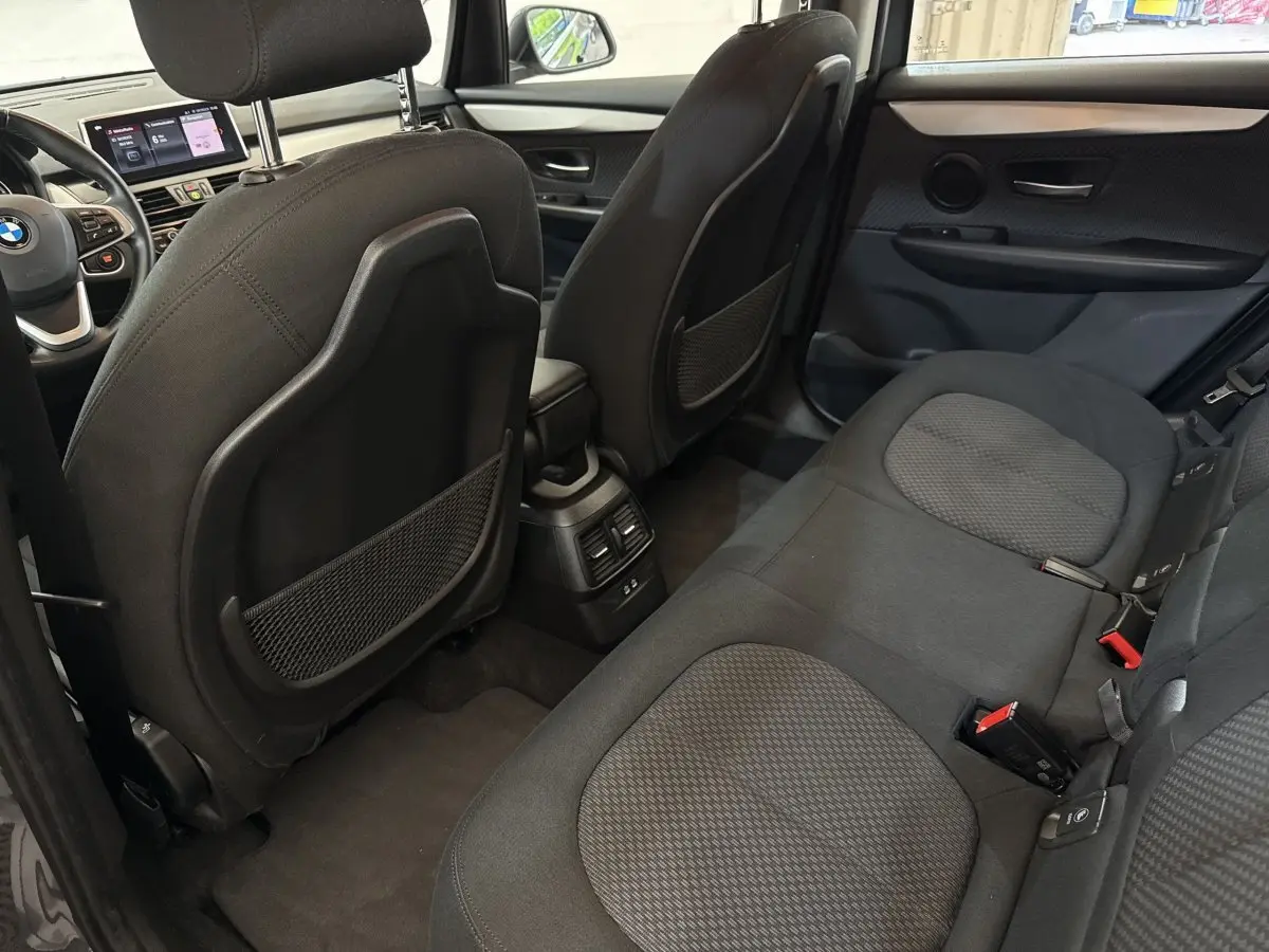 Vue intérieure arrière côté droit de la BMW Série 2 Active Tourer 225xe gris foncé, montrant les sièges et le tableau de bord.
