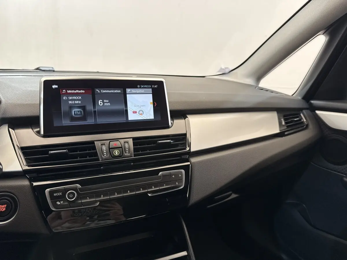 Tableau de bord intérieur de BMW Série 2 Active Tourer gris foncé, avec écran tactile et commandes centrales visibles.