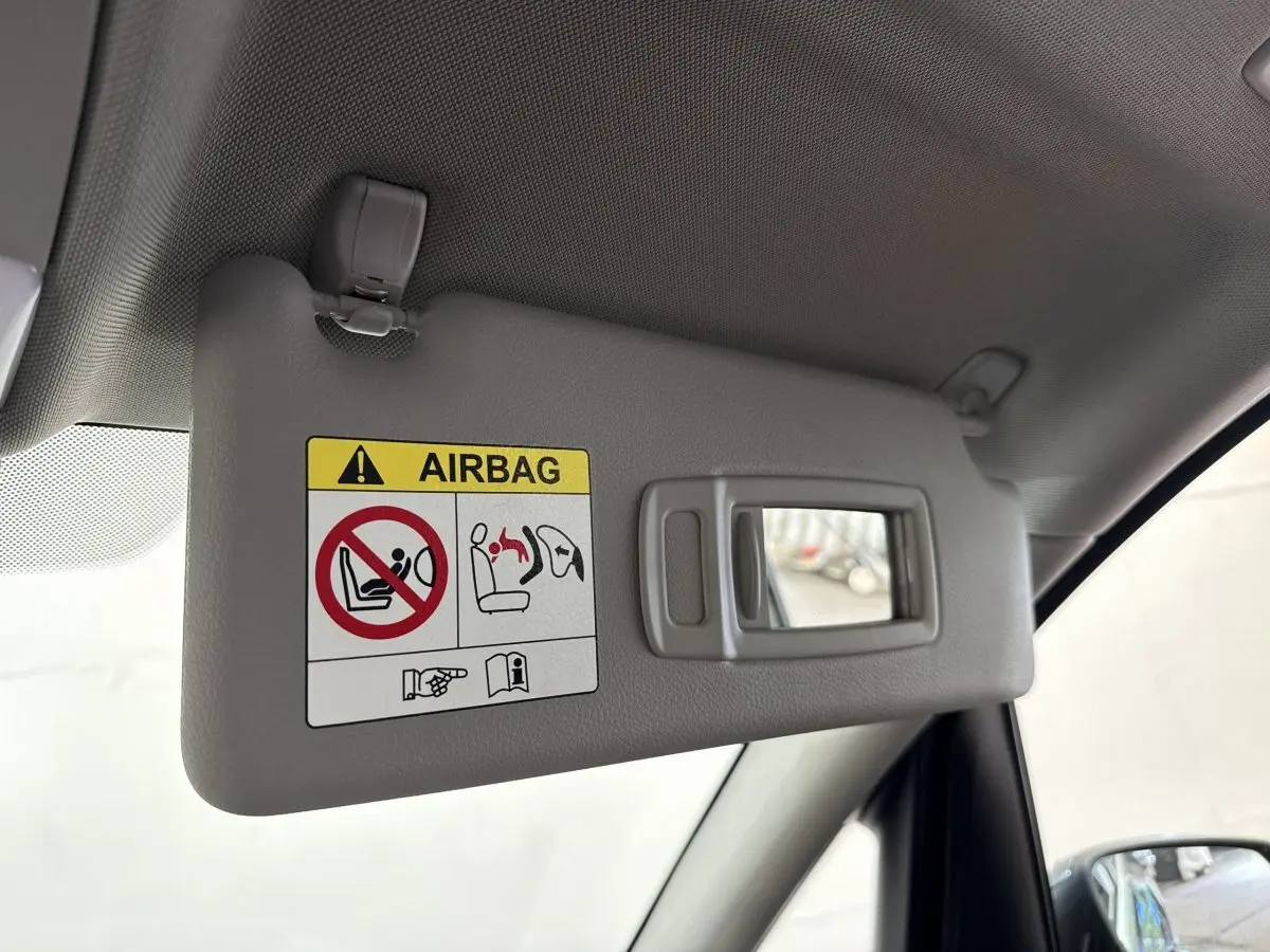 Détail du pare-soleil côté conducteur gris avec miroir intégré dans une BMW Série 2 Active Tourer 225xe gris foncé.