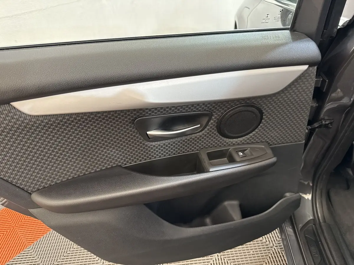 Vue rapprochée de la porte avant droite gris foncé de la BMW Série 2 Active Tourer avec habillage tissu et commandes électriques.