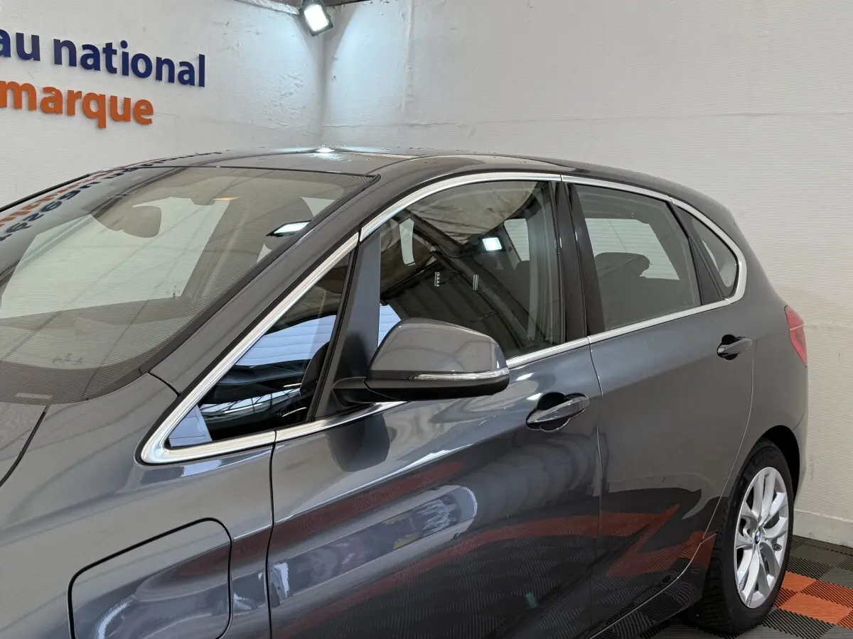 Vue latérale droite d'une BMW Série 2 Active Tourer gris foncé avec jantes alliage et rétroviseurs chromés.