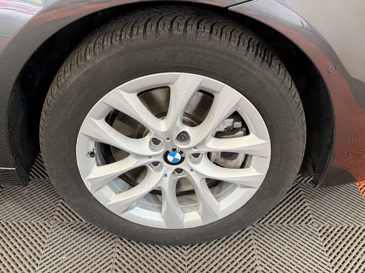Gros plan sur la roue avant droite gris foncé d'une BMW Série 2 Active Tourer avec jante alliage à 5 doubles branches.
