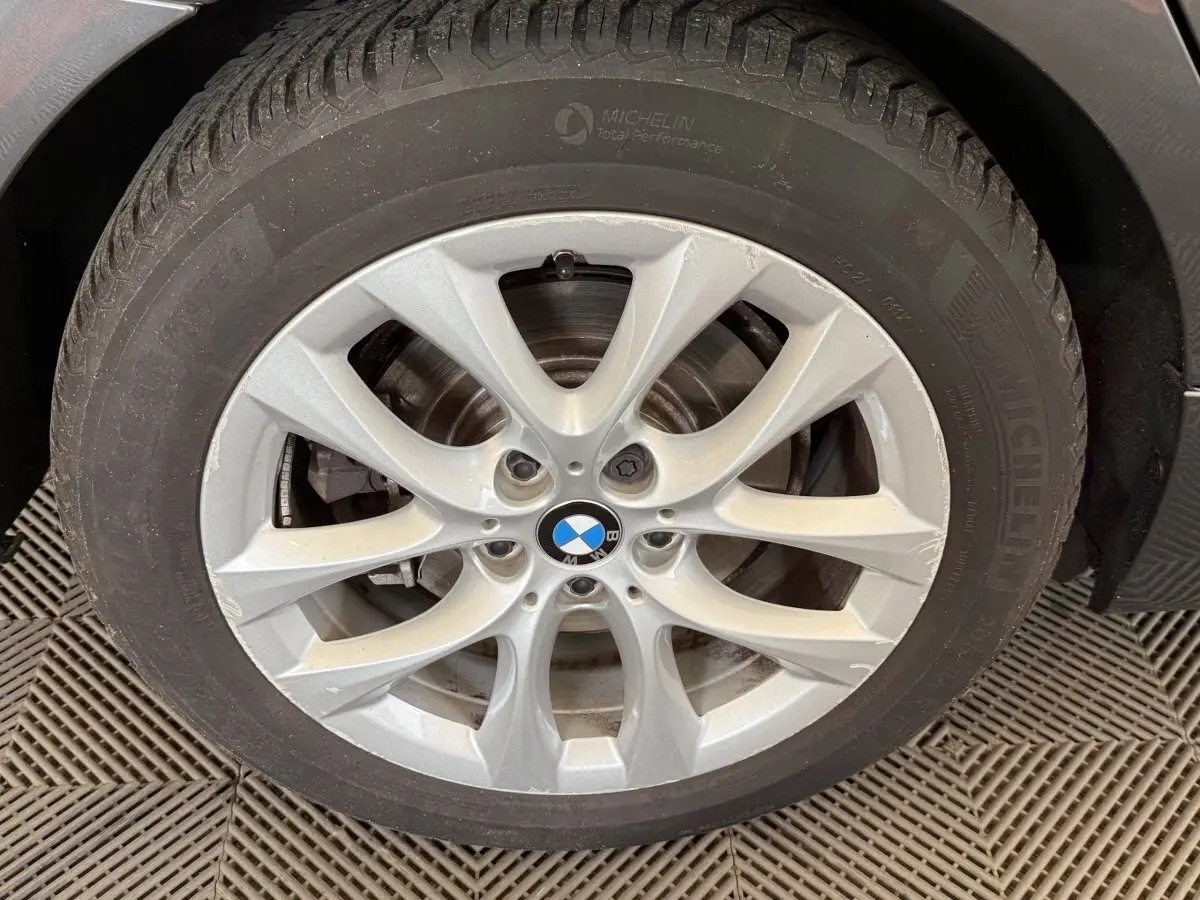 Gros plan sur la roue avant droite avec jante argentée BMW et pneu Michelin sur BMW Série 2 Active Tourer gris foncé.