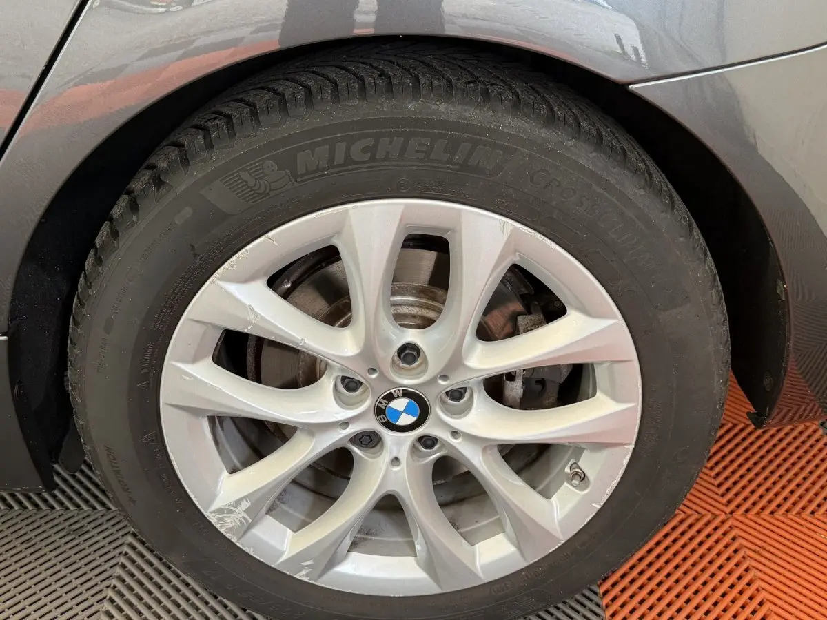 Gros plan sur la roue arrière droite d’une BMW Série 2 Active Tourer 225xe gris foncé, avec passage de roue et partie de carrosserie visible.
