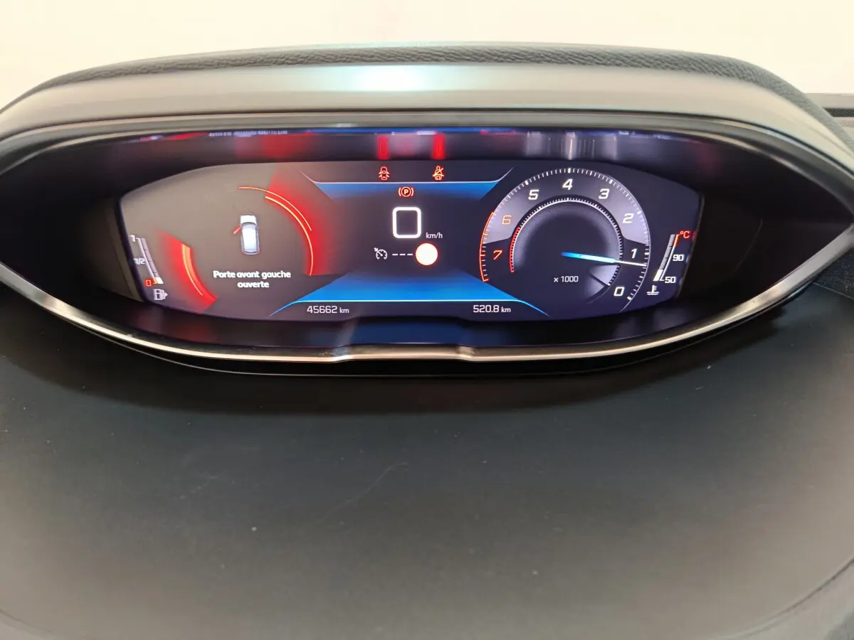 Gros plan sur le tableau de bord numérique du Peugeot 3008 bleu, affichant la vitesse à 0 km/h et porte avant gauche ouverte.
