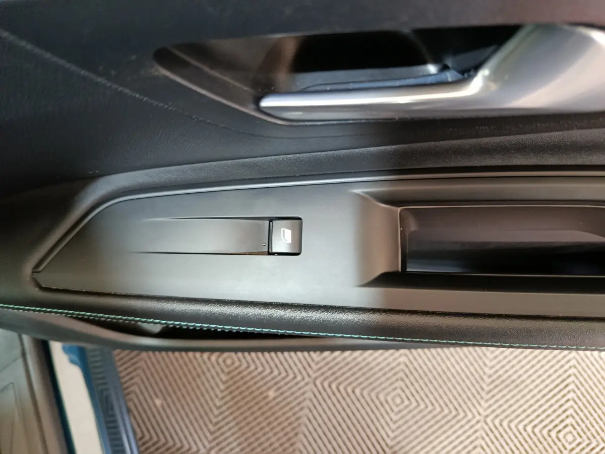 Détail de la poignée intérieure côté gauche noire avec bouton de lève-vitre sur Peugeot 3008 PureTech 130 S&S Allure 2022.