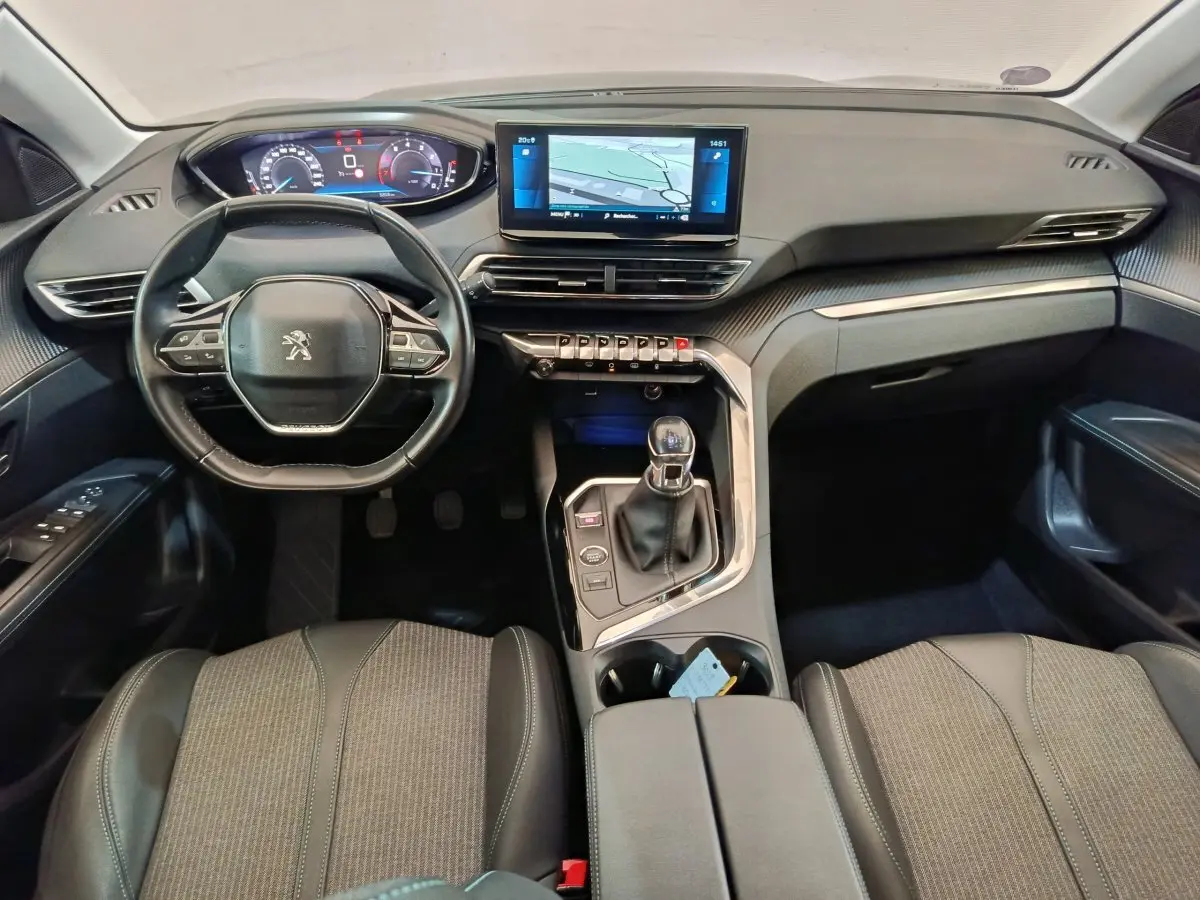 Vue intérieure avant du Peugeot 3008 bleu 2022, tableau de bord moderne avec écran tactile et volant cuir multifonctions.