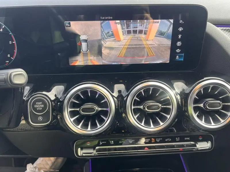 Vue intérieure du tableau de bord d’un Mercedes GLA 200 d AMG Line 2021, avec écran multifonction et aérateurs ronds chromés.