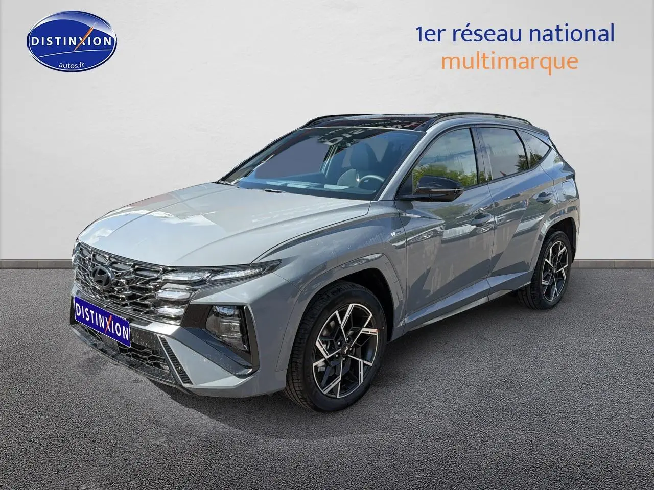 Vue 3/4 avant droite du Hyundai Tucson gris shadow avec calandre chromée et jantes alu distinctives.