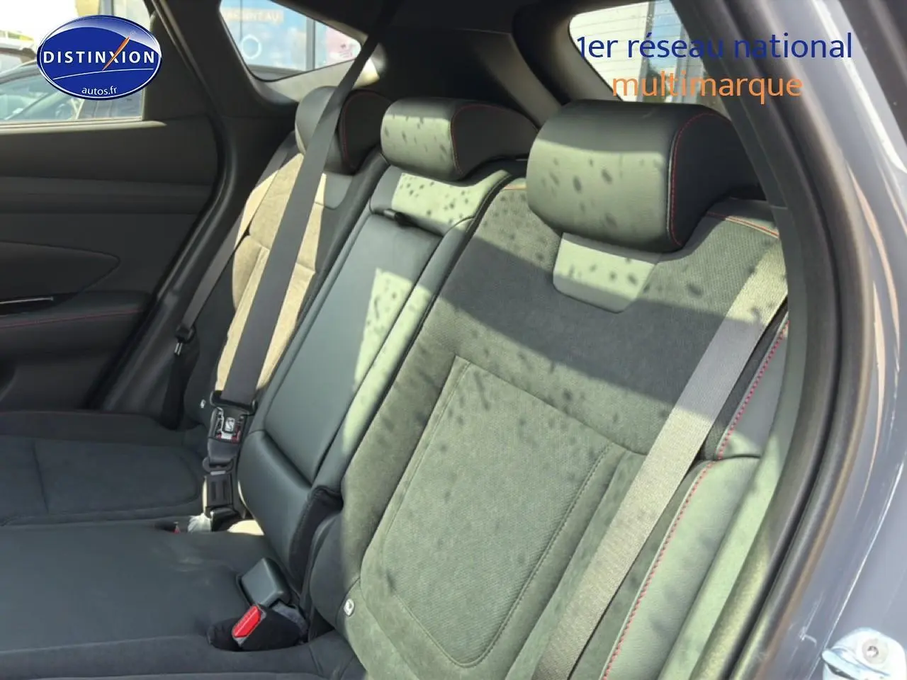 Vue latérale droite des sièges arrière en cuir noir et alcantara avec surpiqûres rouges du Hyundai Tucson 2026 gris shadow.