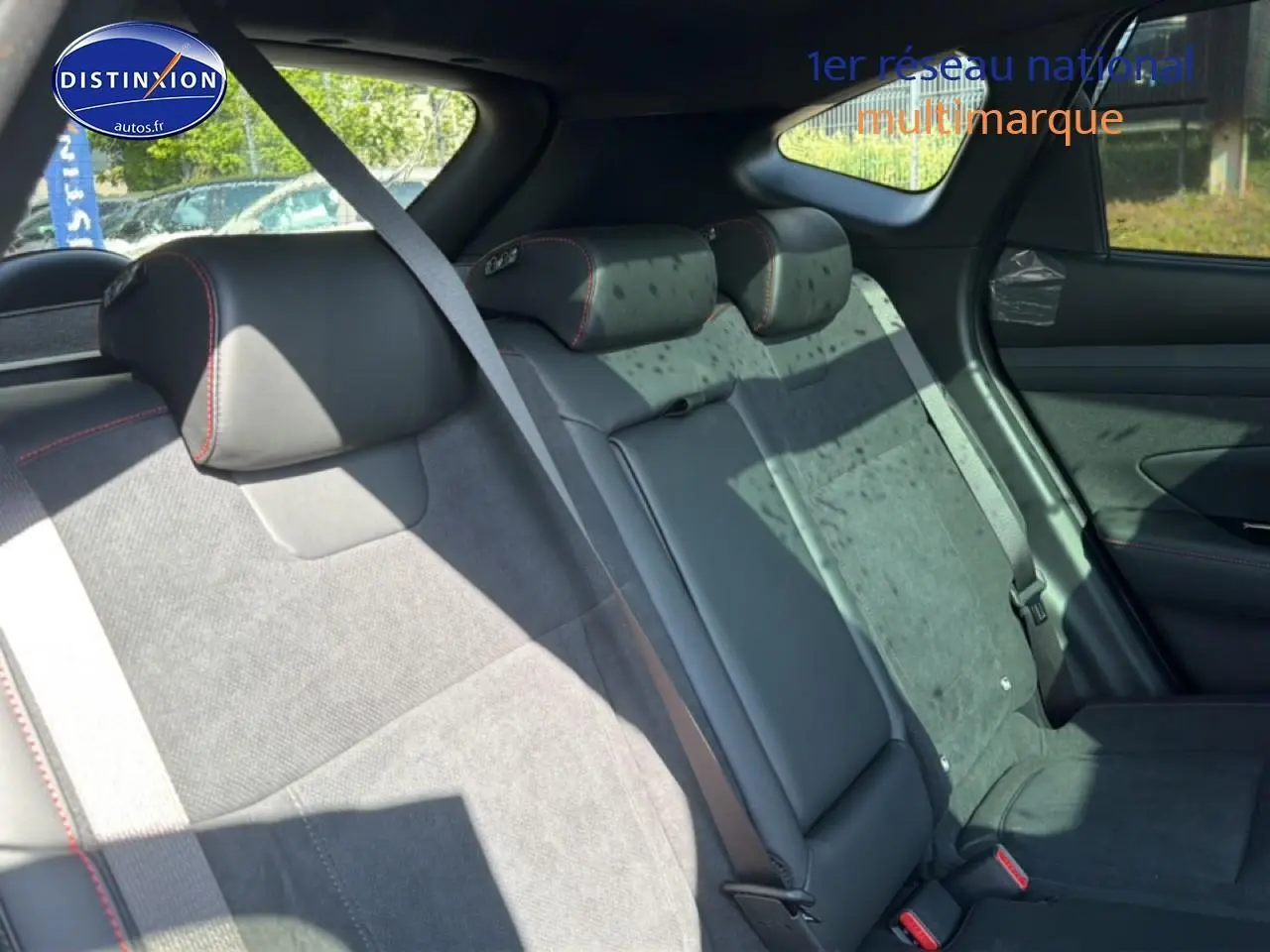 Vue intérieure arrière côté droit du Hyundai Tucson gris shadow, sièges en cuir noir et alcantara avec surpiqûres rouges.