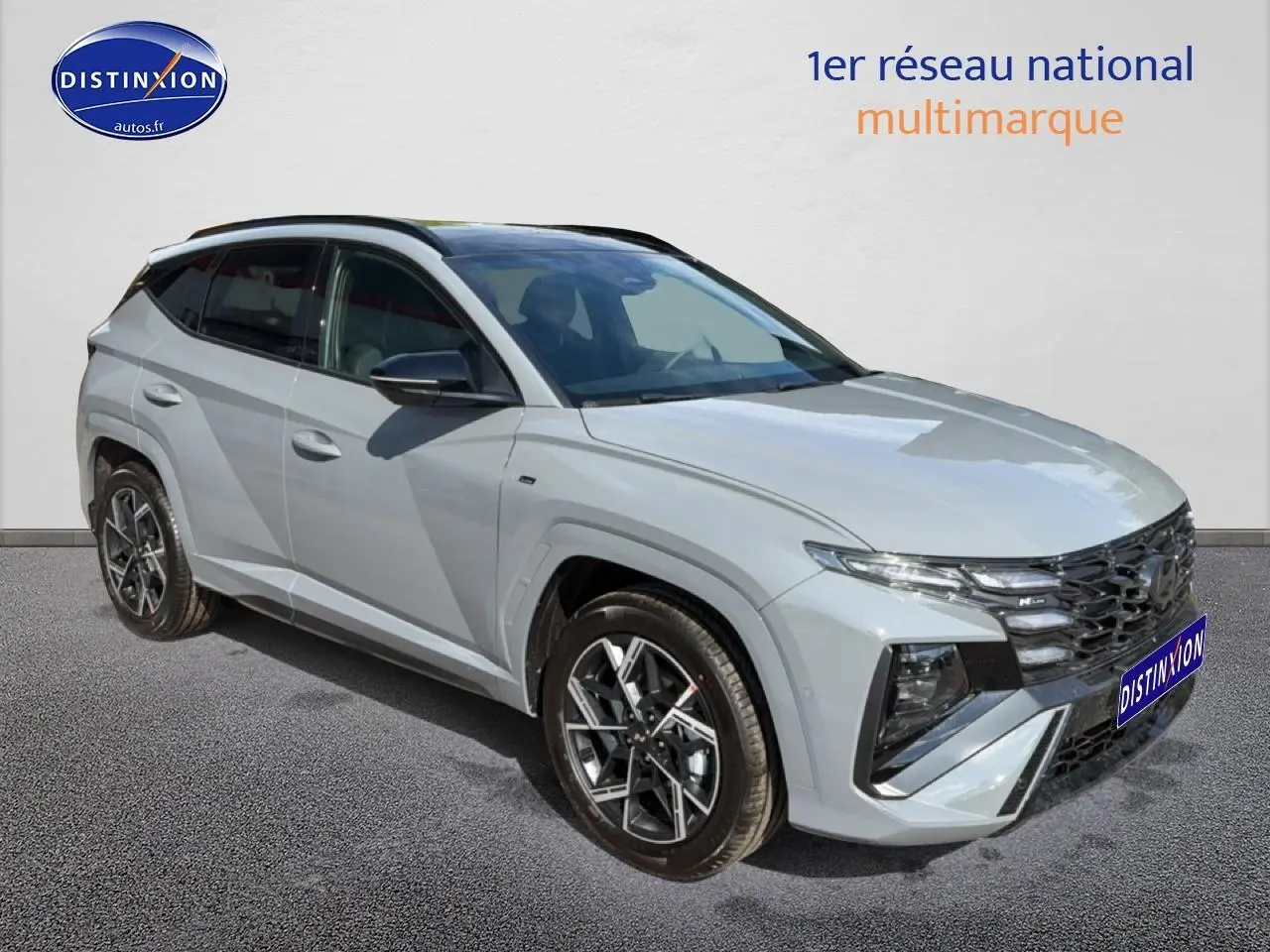 Vue 3/4 avant droite du Hyundai Tucson 2026 gris shadow avec calandre noire et jantes alu distinctives.