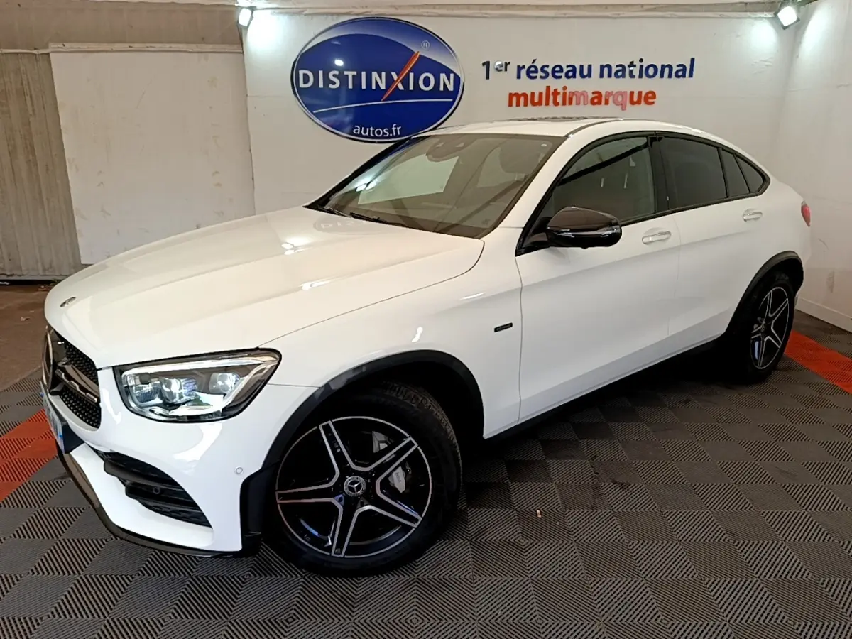 Vue 3/4 avant droit d'un Mercedes GLC Coupé blanc avec jantes AMG noires et vitres teintées.