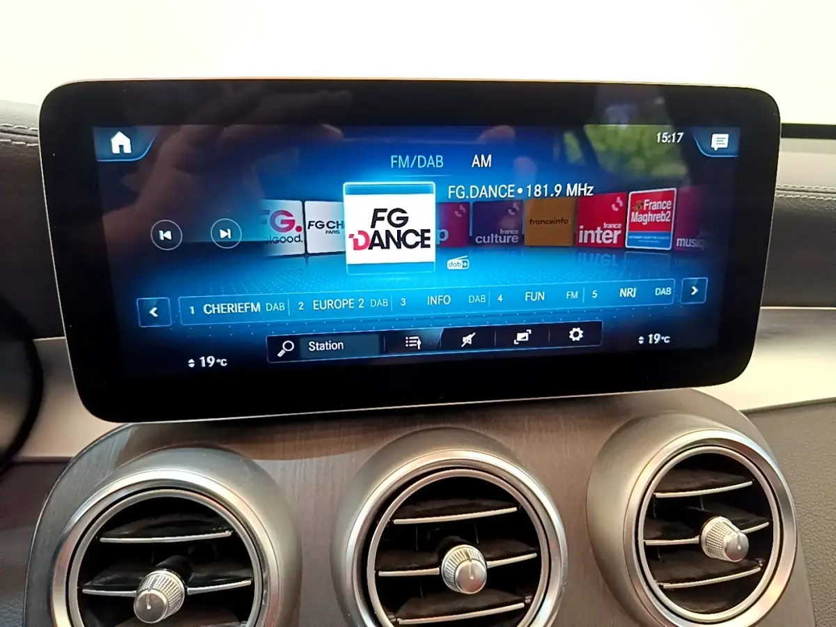 Écran tactile central affichant la radio FM dans l'habitacle du Mercedes GLC 300 e AMG Line blanc, vue intérieure.