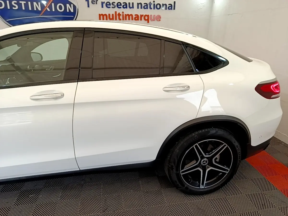 Vue latérale droite d'un Mercedes GLC Coupé blanc avec jantes AMG noires et vitres teintées.