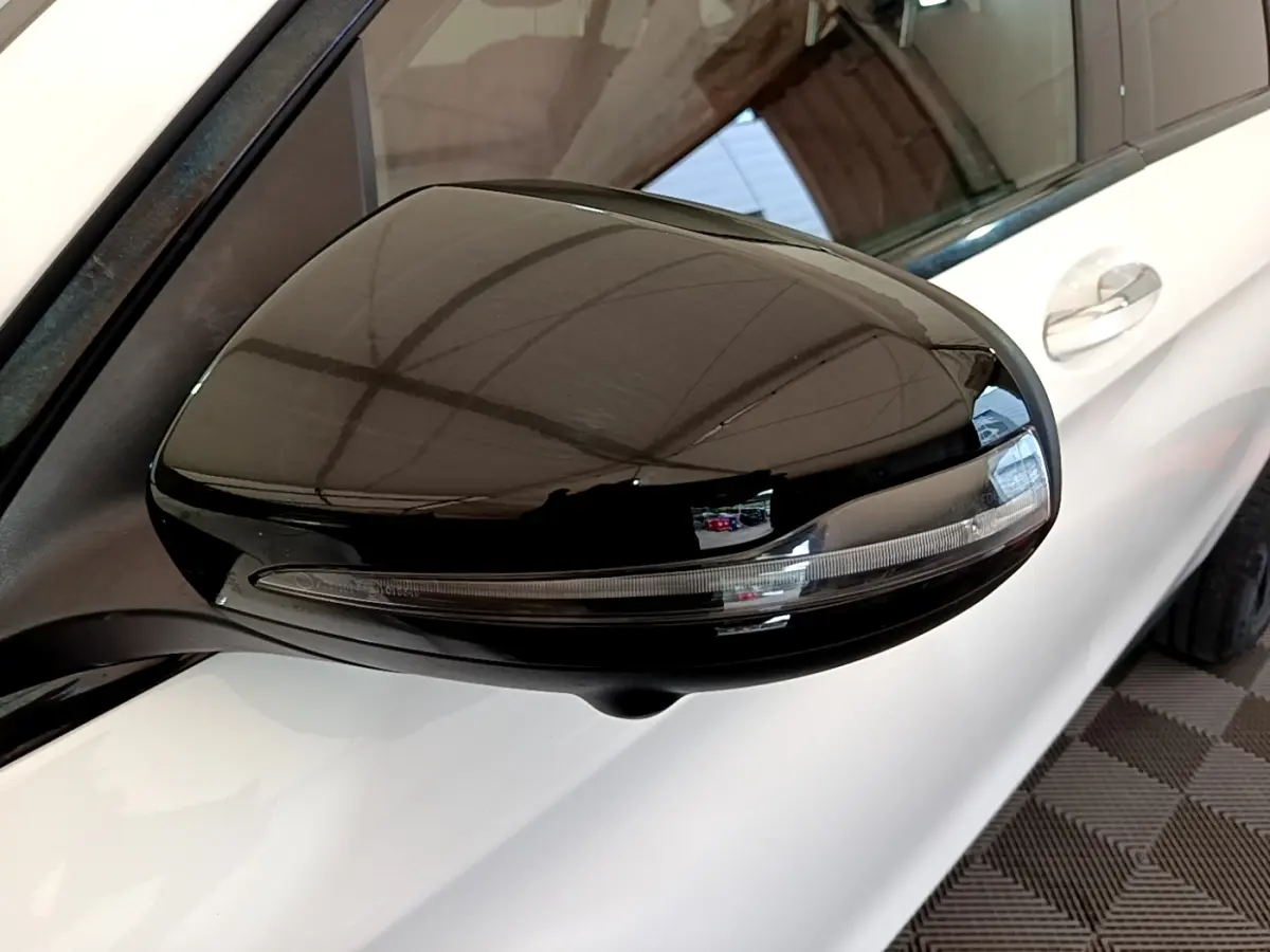 Rétroviseur droit noir brillant avec clignotant intégré sur Mercedes GLC Coupé blanc, vue rapprochée côté avant.